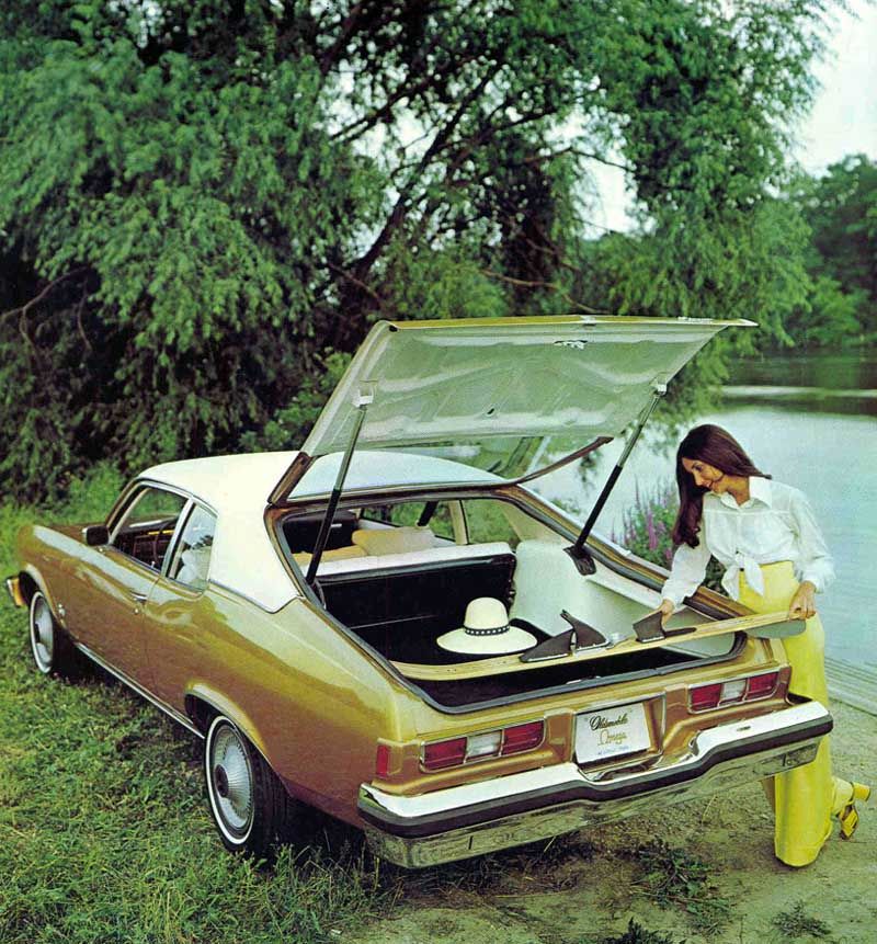 En wakeboard får ledigt plats i Oldsmobile Omega hatchback, men nog ser hon väl inte riktigt klädd ut för sådana vattenäventyr?